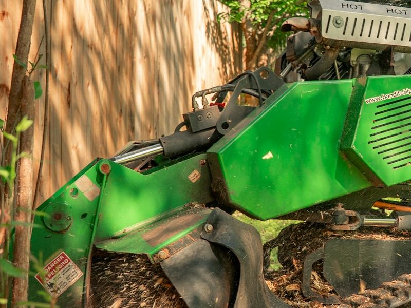 Commercial stump grinder cutting a tree stump below grade in Kansas City